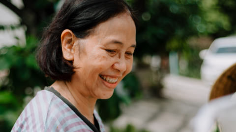 Elderly Woman Buying Vegetables - People with Disability Australia Older woman smiling outside in a garden.