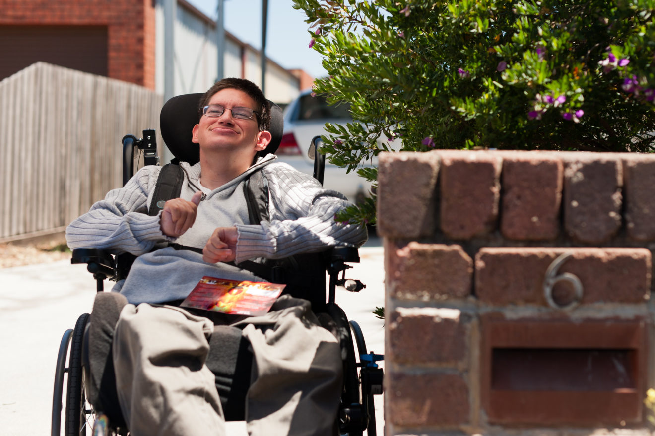 - People with Disability Australia Young Man getting his Mail, seated in his wheelchair